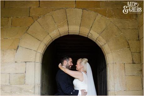 East Riddlesden Hall Wedding Photography pink English garden theme | Bride & groom in arch