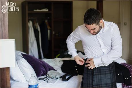 Groom preparation photography East Riddlesden Hall Wedding Photographer putting on kilt