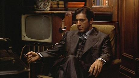 Michael Corleone’s Gray Striped Suit in The Godfather Michael Corleone in his preferred pose: arms relaxed, legs crossed, sitting in an office surrounded by men who will kill for him at the drop of a hat.