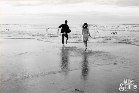 Whitby Love Shoot | Cass & Josh Photography Engagement Shoot in Whitby | Girl wearing Red Flower crown | Alterntive Couple whereing Vintage clothing | Running into the ocean burds scatter