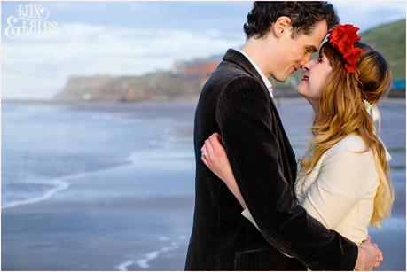 Whitby Love Shoot | Cass & Josh Photography Engagement Shoot in Whitby | Girl wearing Red Flower crown | Alterntive Couple whereing Vintage clothing | Couple hugging in the sunset at the beach