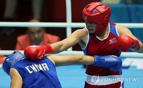 One of the DPRK's 11 gold medallists,  Jang Un Hui (right) connects to PRC's Li Qian during the women's middleweight boxing finals on October 1, 2014 at the 17th Asian Games in Incheon, ROK (Photo: Yonhap).
