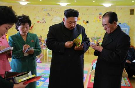 Kim Jong Un leafs through a children's book during a visit to the Pyongyang Baby Home and Orphanage on January 1, 2015.  Also in attendance is Ri Ch'ae-il (right), senior deputy director of the WPK Propaganda and Agitation Department (Photo: Rodong Sinmun).