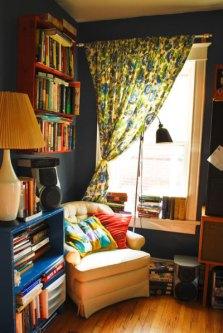 Living Room Corner Reading Nook Dark Gray Walls Yellow Chair Cluttered Cozy Floral Curtains Interior Decor