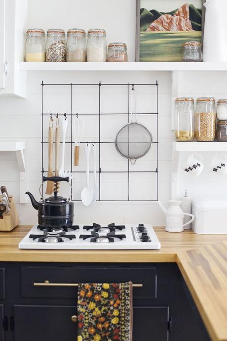 Balancing a simplistic but eclectic style I like the rack she's hung behind her stove top - practical and attractive.