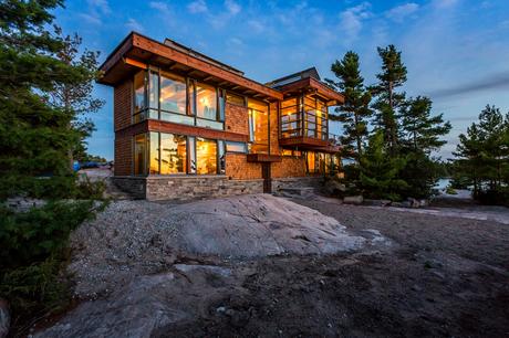 Modern Meets Rugged at This Off-the-Grid Retreat in Ontario Charles Gane wood cottage exterior at night.