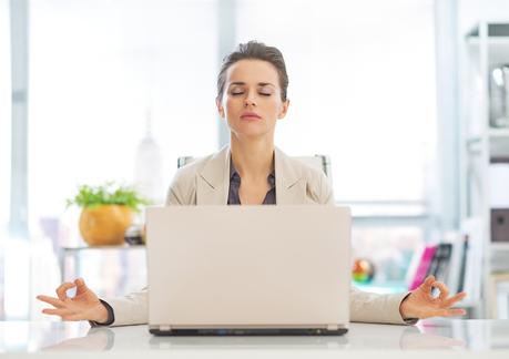Are Your Emotions Getting In the Way of Your Success? Business Woman Meditating Near Laptop