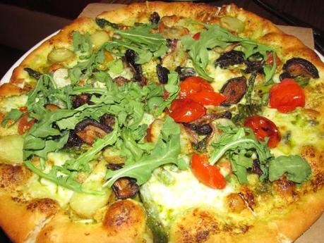 Spring Pizza with grilled asparagus, wild mushrooms, baby red potatoes, pesto, oven-dried tomatoes, and fresh arugula. 
