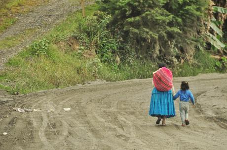 A lady and her son walking down the road.