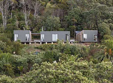 Modern prefab New Zealand beach house facade the tries to preserve mature trees
