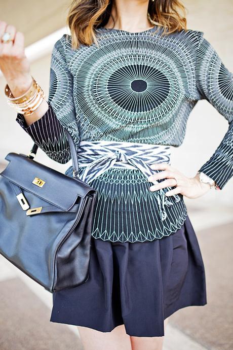pattern mixing geometric top and ikat obi belt, miu miu faille skirt, hermes kelly bag, how to wear black