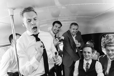 Revelry and shenanigans with wedding guests on double decker bus at fun wedding