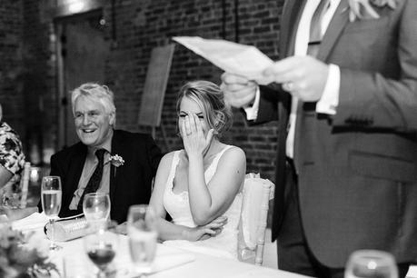 Bride covering face during embarassing moment at wedding speeches