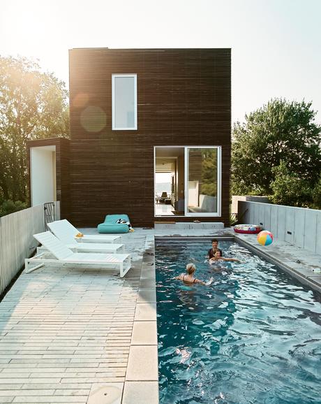 An Idyllic Rhode Island Summer Cottage Is the Perfect Escape for a New York Family Pool terrace with Eos lounge chairs at Rhode Island family vacation home by Bernheimer Architecture.