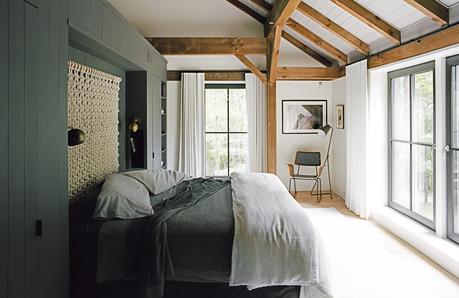 The master bedroom features brass details and a textured wall hanging.