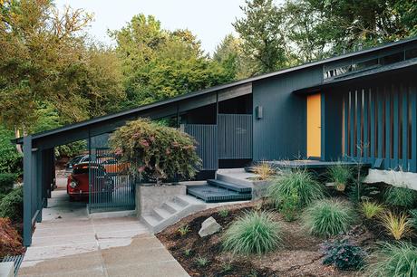 Midcentury house in Portland with iron colored facade and gold front door