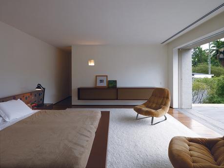 Kogan designed a number of the built-in furnishings, including the headboard and cupboard in the master bedroom.The cupboard is deliberately reminiscent of a mid-century stereo speaker. The vintage lounge chairs are by Percival Lafer.