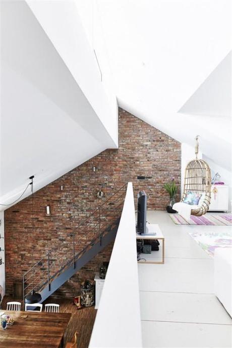 Living with a Loft Frankfort, Germany | Built from a recycled barn, one entire side of the house is built from the old barn brick, each of which have been washed with a brush. Beams have been recycled as structural support for the mezzanine where there's a family room (with a lovely wicker swing!) and study. Love the stairs and the multi-angled ceiling as well.: