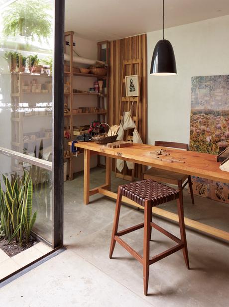 A leather stool and wood table complete a modern studio in Argentina. 