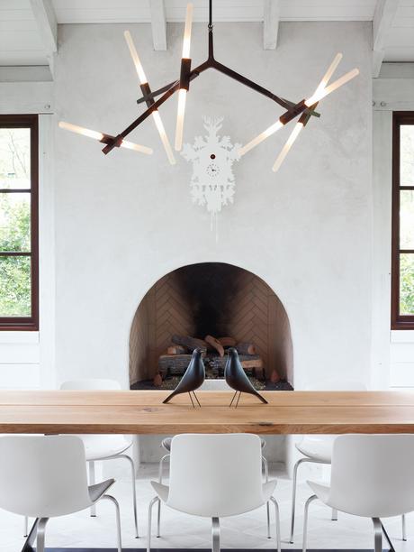 modern dining space with chandelier and Eames house birds