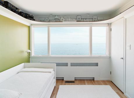 Upstairs, the bedrooms are arranged in a uniform line of five cubicles. Initially, each bedroom had a vividly colored western wall—red, blue, yellow, or green—with the remaining three walls painted white.