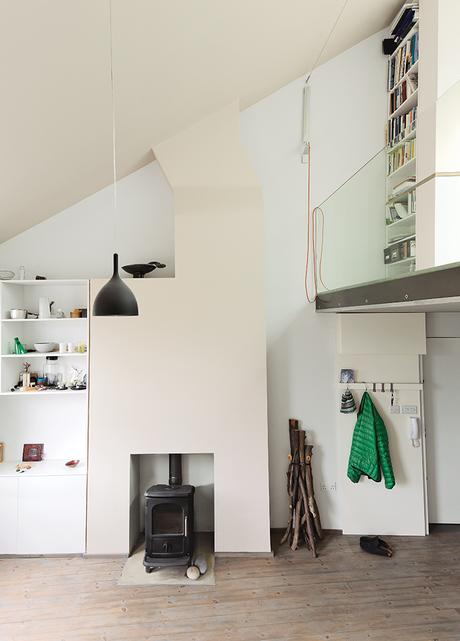 White interior with a wood burning stove and storage shelves