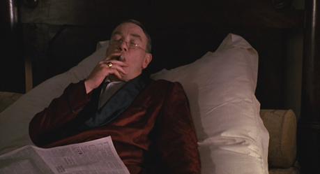 Leo’s Red Silk Robe in Miller’s Crossing Leo relaxes comfortably at the intersection of leisure and luxury.