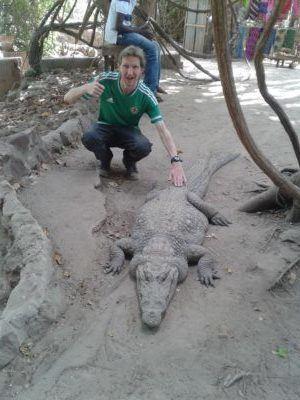 Stroking Crocodiles at Kachikally Pool, Bakau, The Gambia Stroking Crocodiles at Kachikally Pool, Bakau, The Gambia