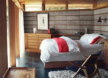 Modern home renovation in Napa includes redwood and concrete bedroom with hans wegner chair
