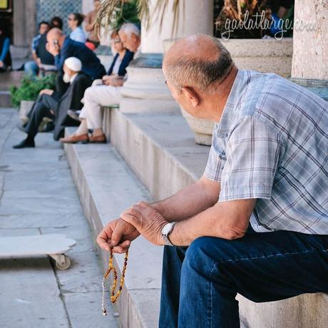 Thinking of Istanbul a man holding tespih beads at Yeni Cami (New Mosque), Istanbul