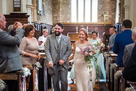 Rustic Wedding with Adam + Jaclyn bride and groom walking out of hillmorton church