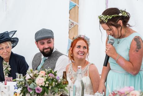 Rustic Wedding with Adam + Jaclyn bride smiling at her sisters wedding speech