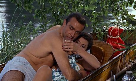 From Russia With Love – Bond’s Gingham Shirt and Swim Trunks Bond's swim trunks go to waste as his call from work ensures that the champagne is the only thing getting wet in this scene. Unless...