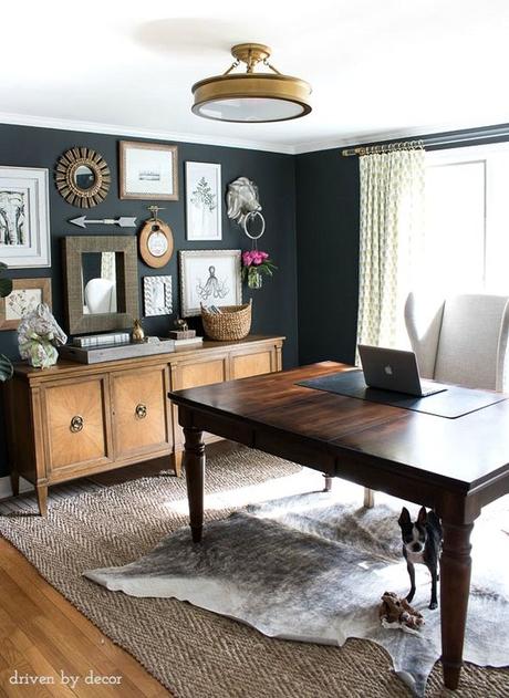 Home office with charcoal gray walls and eclectic gallery wall above a credenza: 