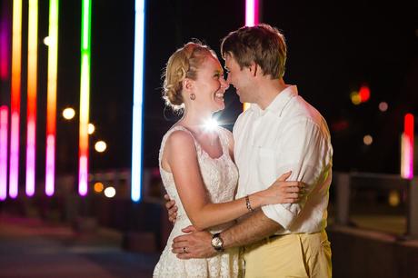 Brdie and groom on bridge with rainbow lights