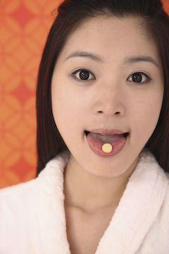 holding vitamin c tablet on tongue