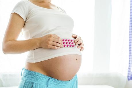 pregnant woman holding pills