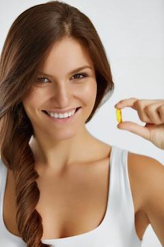 woman hold fish oil capsule
