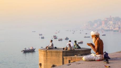 Man praying in Varanasi, India overlooking the river