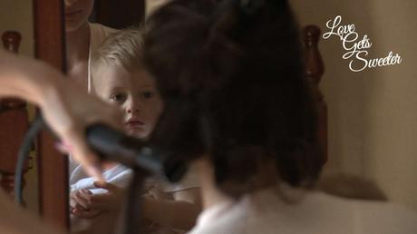 An Elegant and Stylish Lakes Wedding Video page boy sitting on the knee of a bridesmaid while she gets her hair done at Armathwaite Hall
