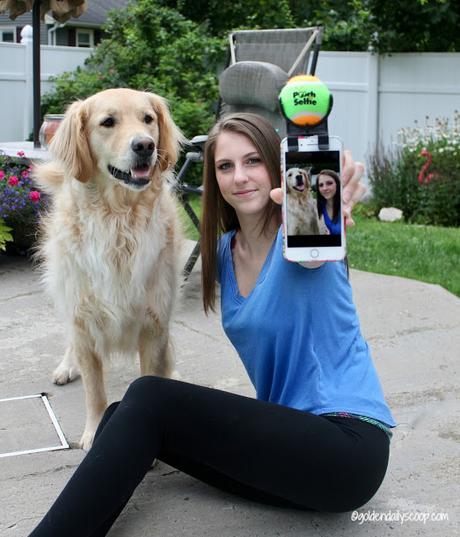 teenage girl taking selfie with golden retriever dog using the pooch selfie