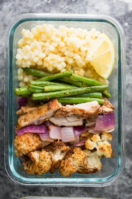 Moroccan couscous meal prep bowls with chicken thighs, roasted cauliflower, green beans and red onions. A delicious meal prep lunch recipe that also makes a great dinner!