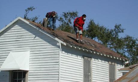 When, Why, and How to Clean Your Roof two roofers cleaning a roof