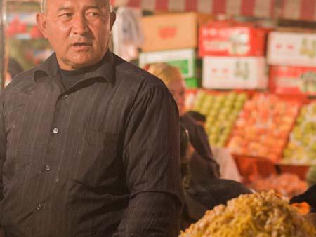 Uighur man selling chickpeas and capsicum