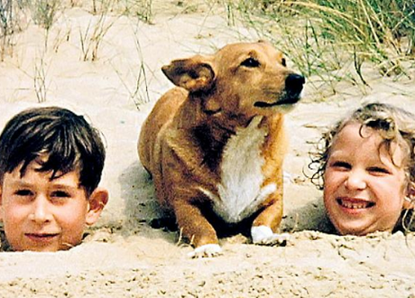 Prince Charles and Princess Anne, buried in the sand