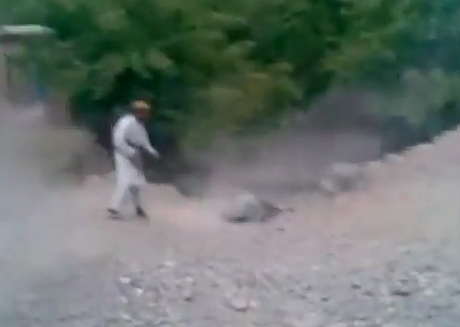 A Taliban fighter executes a woman reportedly accused of adultery.