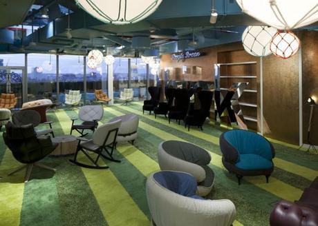 The interior communal areas have been furnished in a fun style, reminiscent of cozy living rooms, complete with high-backed armchairs, scattered pillows and woolen pouffes in the rainbow of Google corporate colors, and clusters of small rocking chairs.