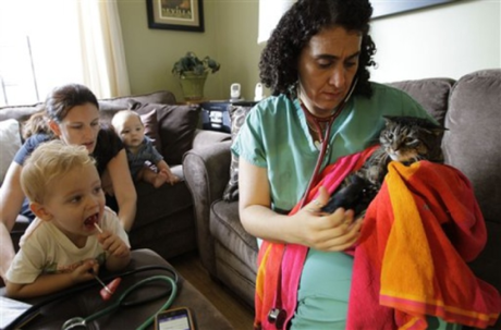 Dr. Elisabetta Coletti tends to cat while family looks on: © Associated Press, photo by Kathy Willems