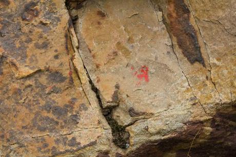 faded red arrow on rock