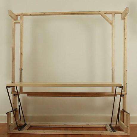 The wooden frame rests against a wall, lifting up the full-size desk in the process The wooden frame rests against a wall, lifting up the full-size desk in the process